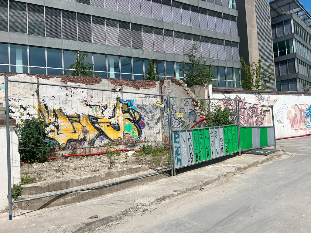 graffiti on crumbling wall and fence barrier